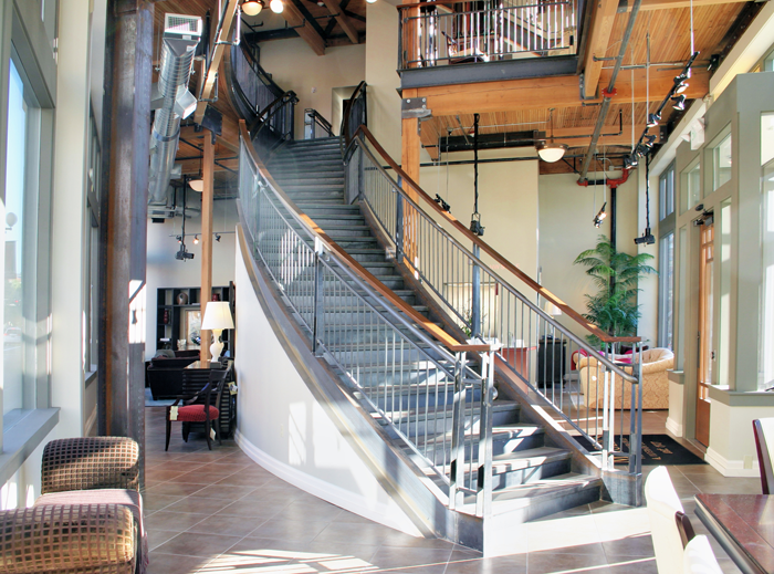 The second floor of the corner building was opened up to allow a dramatic sweeping staircase within the furniture gallery. Photo by Bob Kovalenko.